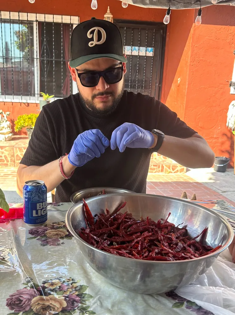 The founder hand-sorting dried chiles